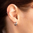 Close-up of a person wearing a silver hoop earring.