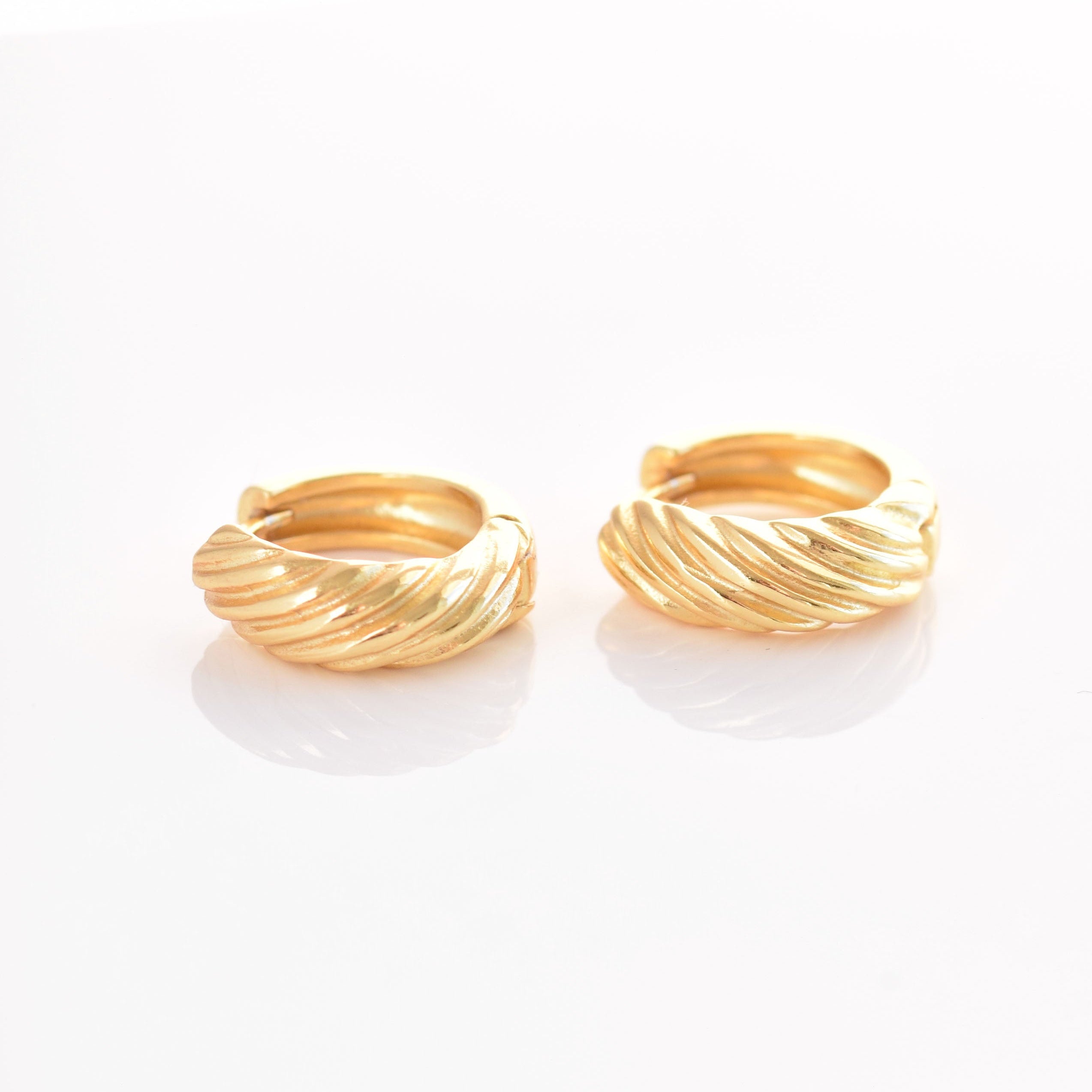 Pair of gold hoop earrings on a white background